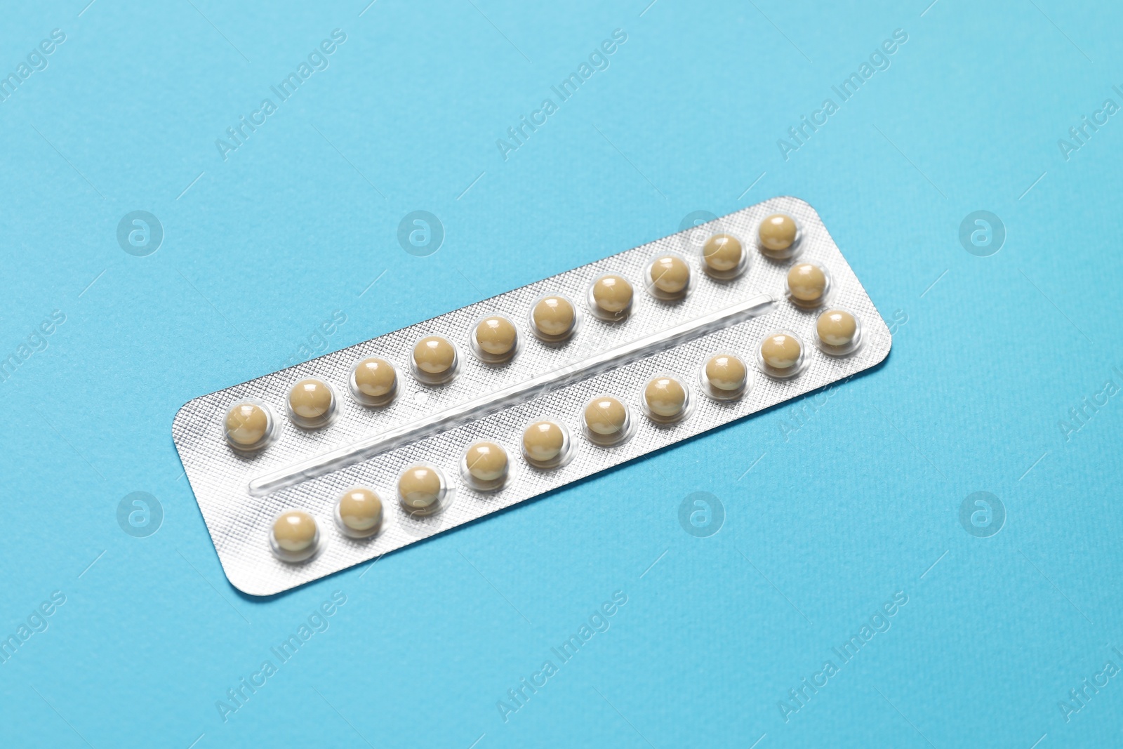 Photo of Blister of contraceptive pills on light blue background