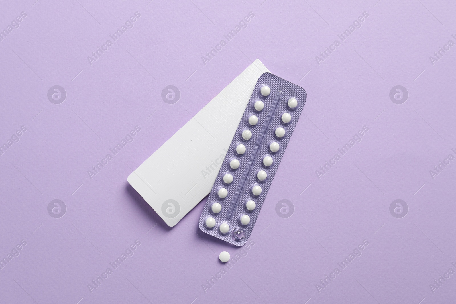 Photo of Blister of contraceptive pills and package on lilac background, top view. Mockup for design