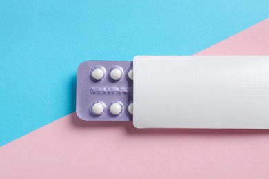 Photo of Blister of contraceptive pills in package on color background, top view. Mockup for design
