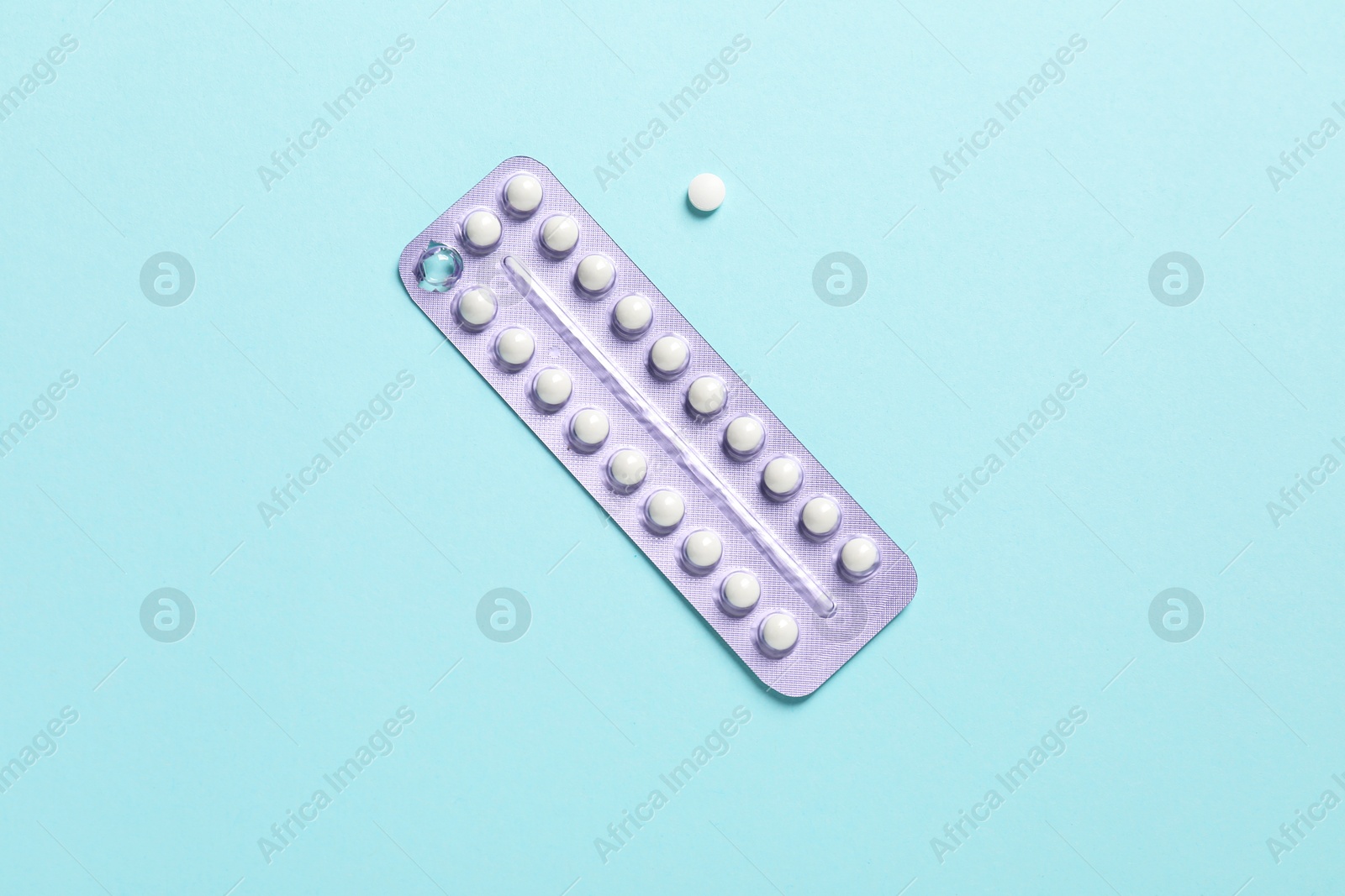 Photo of Blister of contraceptive pills on light blue background, top view