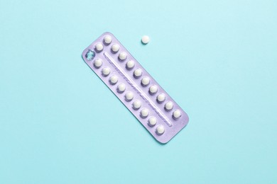 Blister of contraceptive pills on light blue background, top view