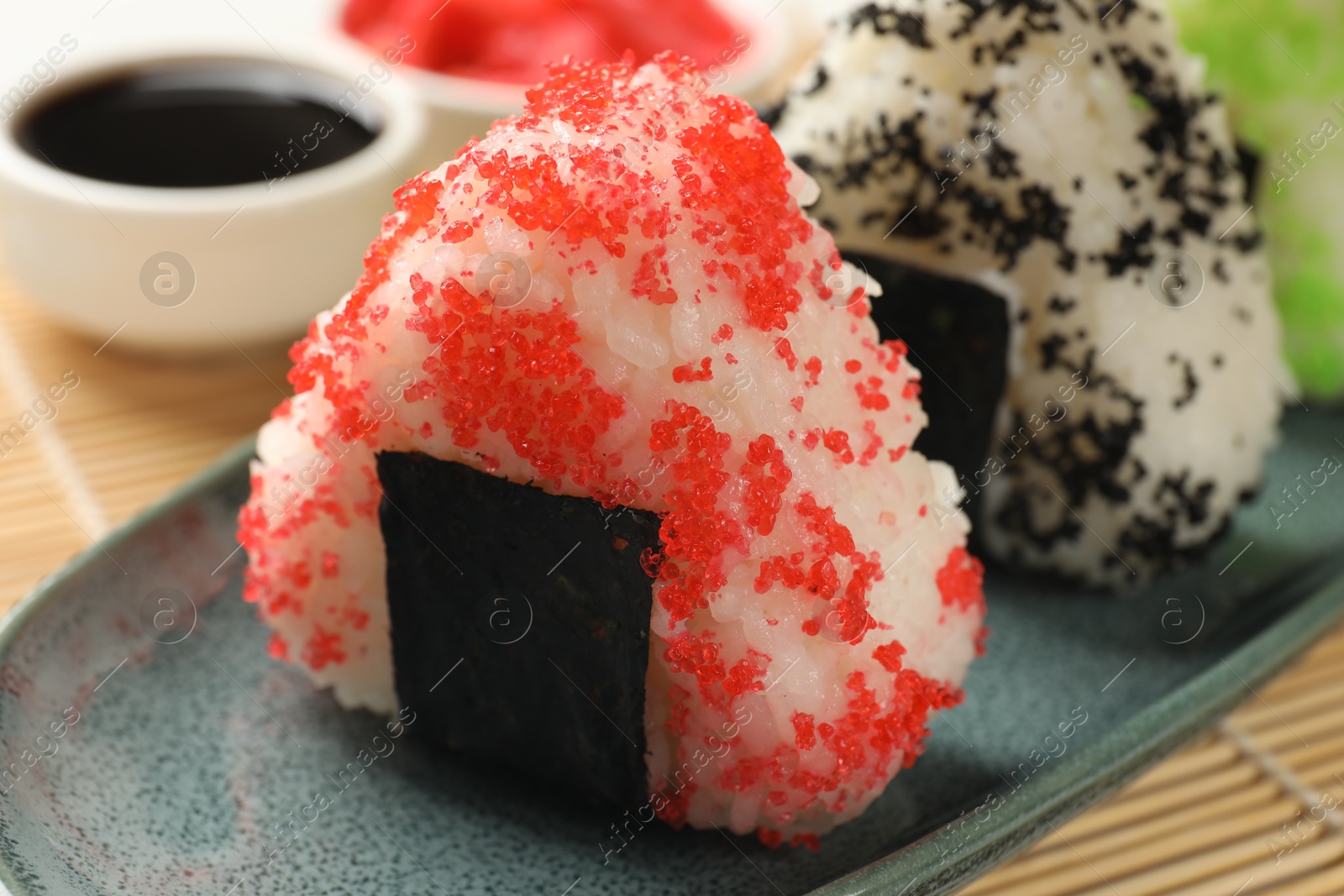 Photo of Tasty tobiko onigiri (Japanese rice balls) served on table, closeup