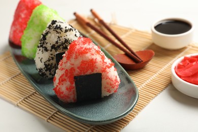 Photo of Tasty tobiko onigiri (Japanese rice balls) served on white table, closeup