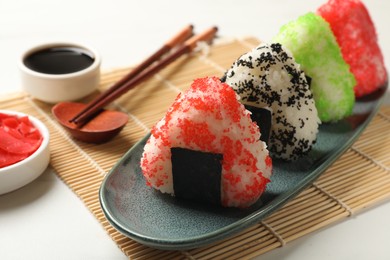 Photo of Tasty tobiko onigiri (Japanese rice balls) served on white table, closeup