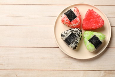 Photo of Tasty tobiko onigiri (Japanese rice balls) on white wooden table, top view. Space for text