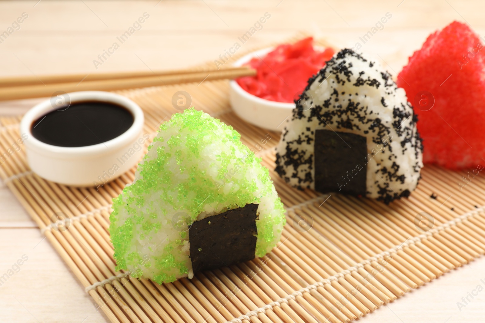 Photo of Tasty tobiko onigiri (Japanese rice balls) served on white table, closeup