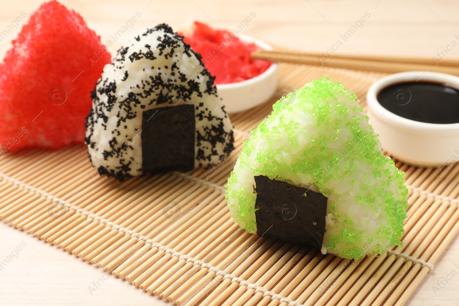 Photo of Tasty tobiko onigiri (Japanese rice balls) served on white table, closeup