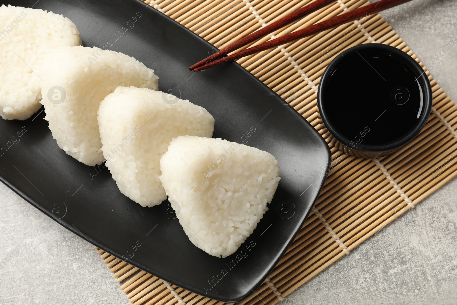 Photo of Tasty onigiri (Japanese rice balls) served on grey table, flat lay