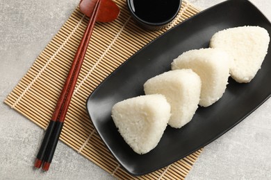 Photo of Tasty onigiri (Japanese rice balls) served on grey table, flat lay