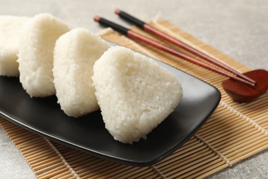 Photo of Tasty onigiri (Japanese rice balls) served on grey table, closeup