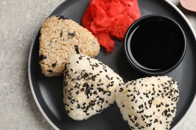 Photo of Tasty onigiri (Japanese rice balls) served on grey table, top view