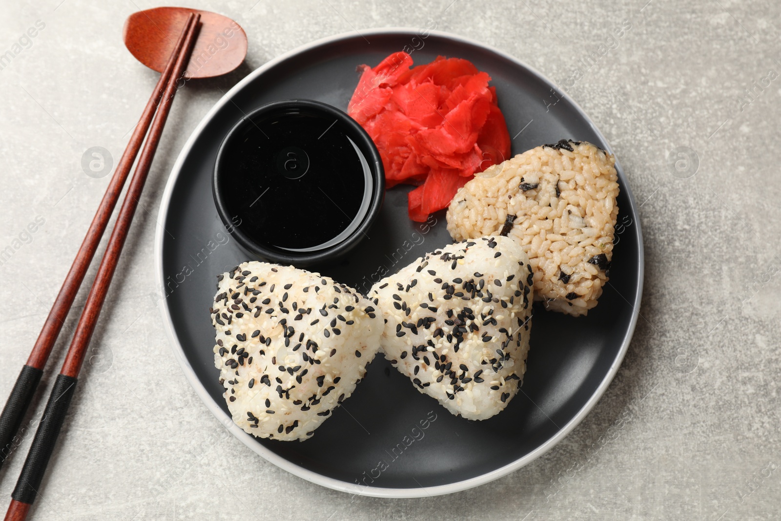 Photo of Tasty onigiri (Japanese rice balls) served on grey table, top view