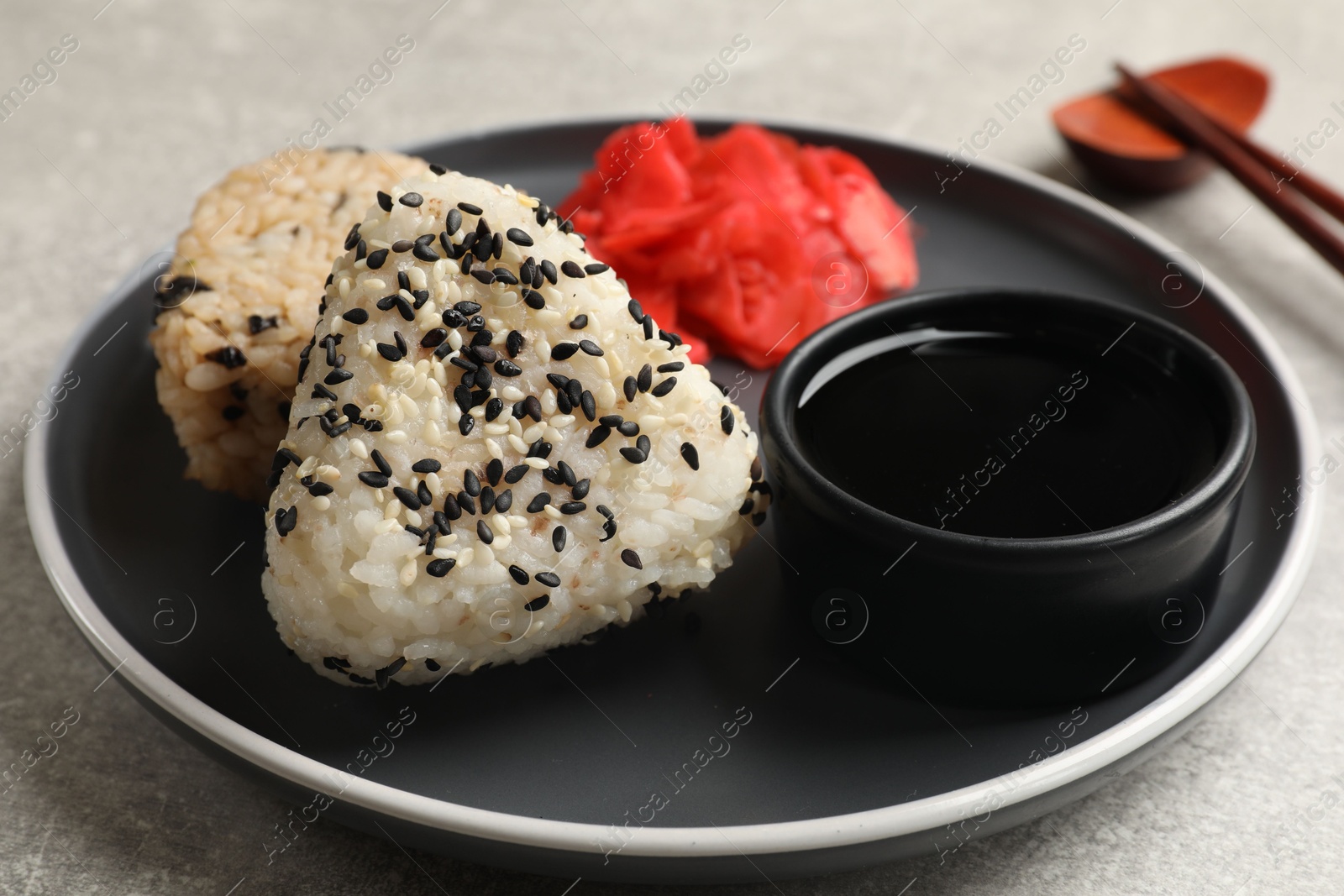 Photo of Tasty onigiri (Japanese rice balls) served on grey table, closeup