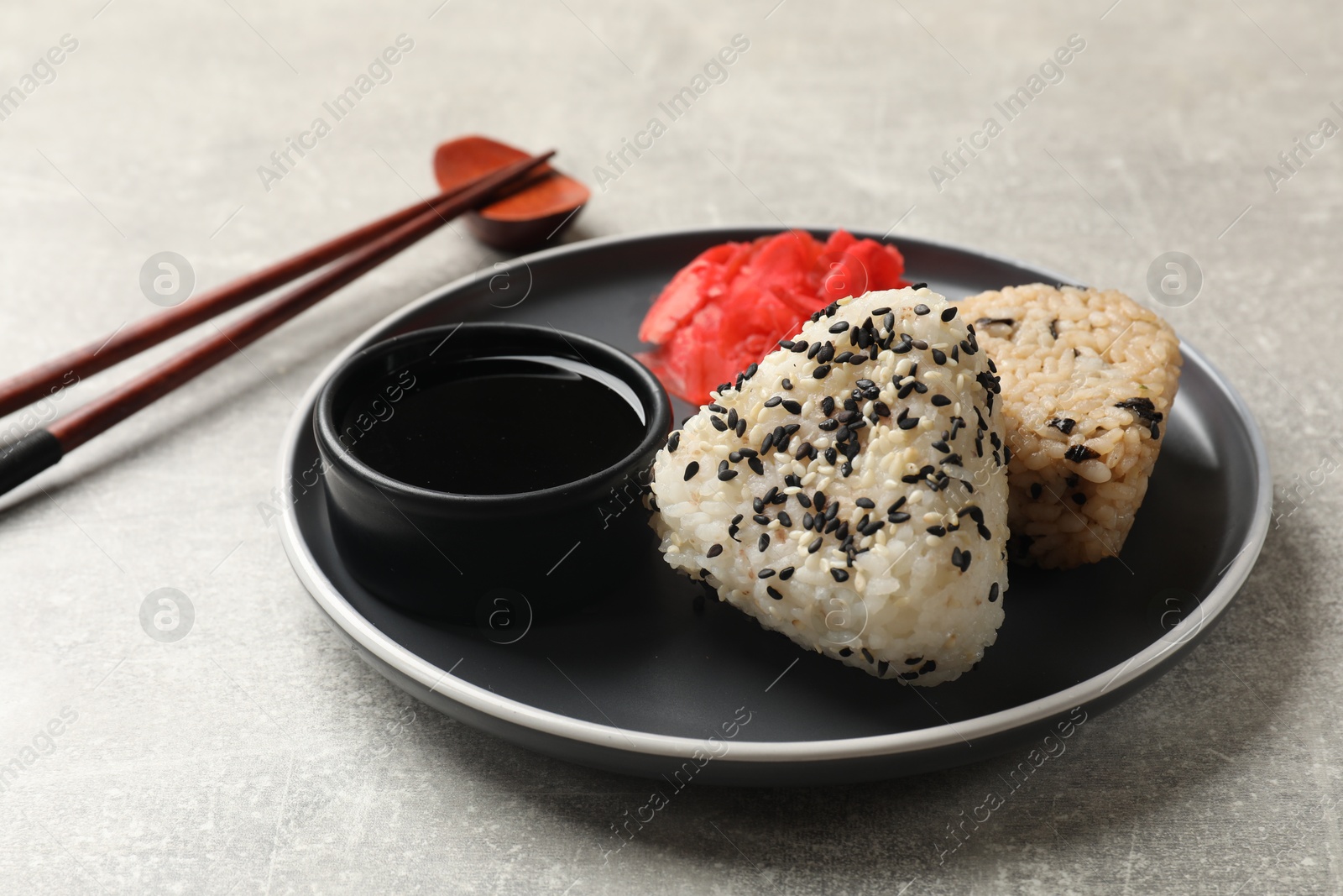 Photo of Tasty onigiri (Japanese rice balls) served on grey table, closeup