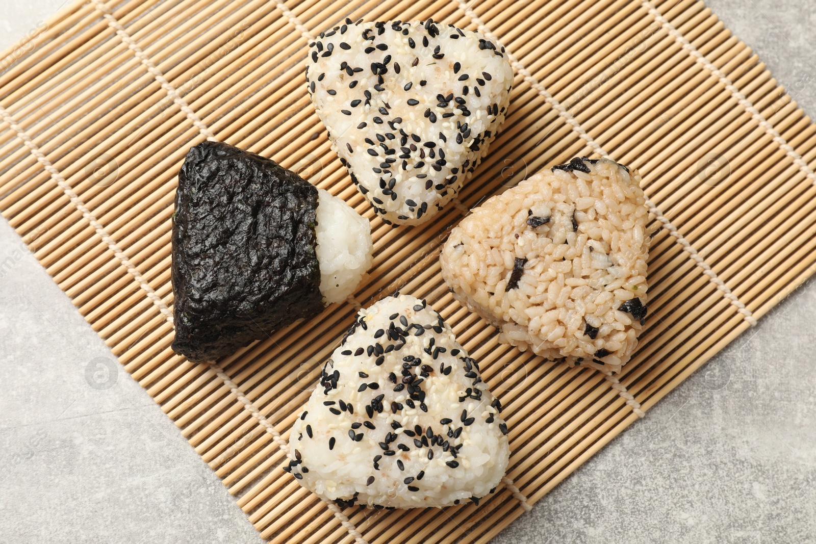 Photo of Tasty onigiri (Japanese rice balls) on grey table, top view