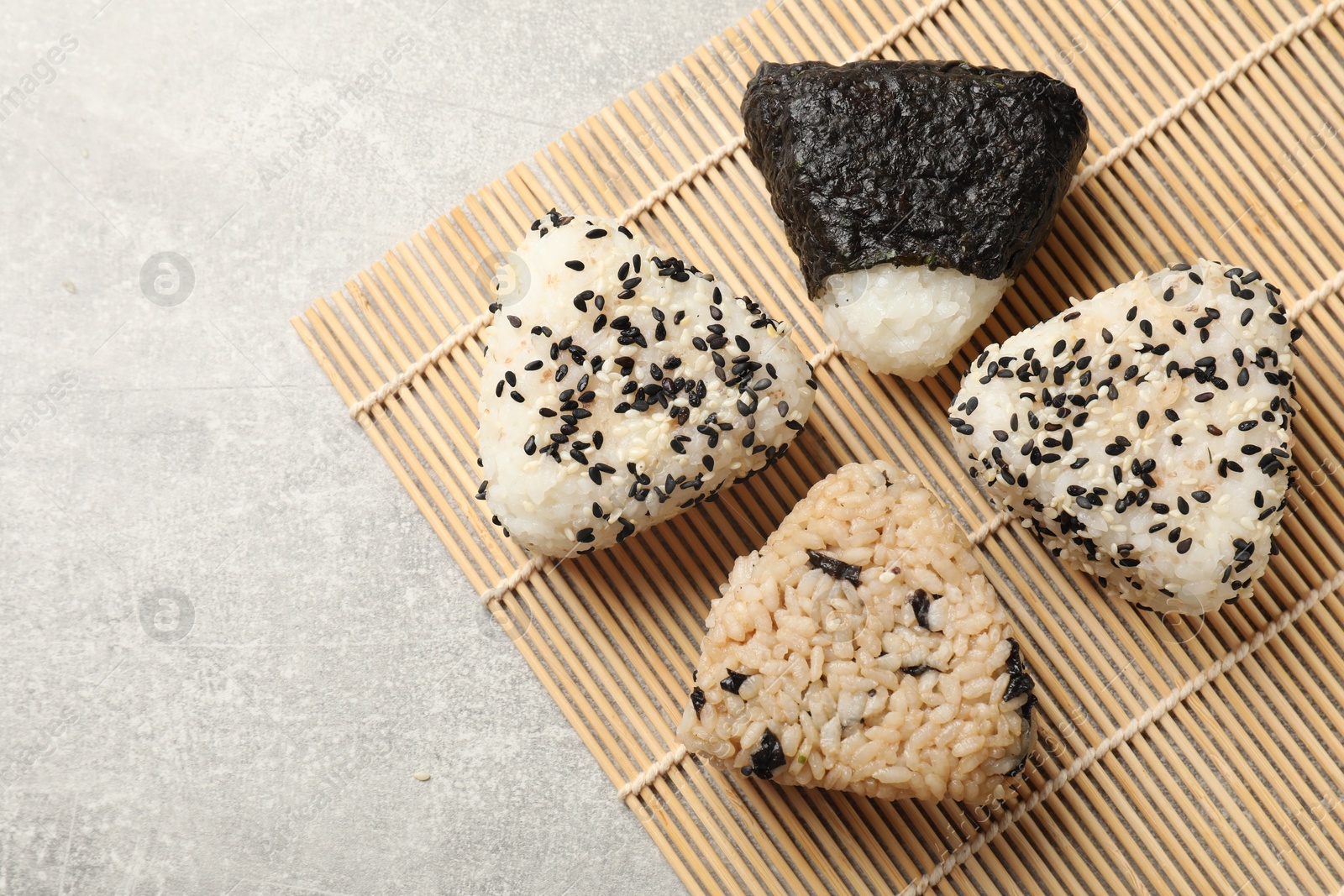 Photo of Tasty onigiri (Japanese rice balls) on grey table, top view