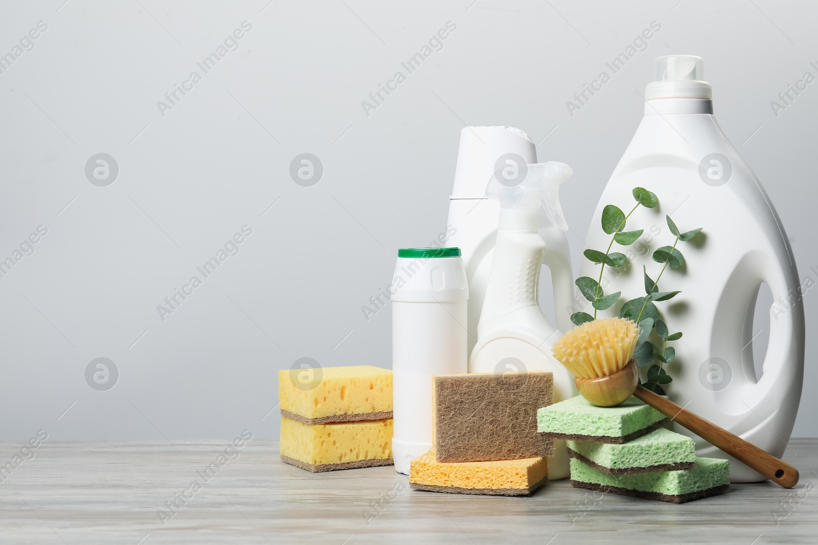 Photo of Eco-friendly cleaning products, supplies and eucalyptus branches on wooden table, space for text