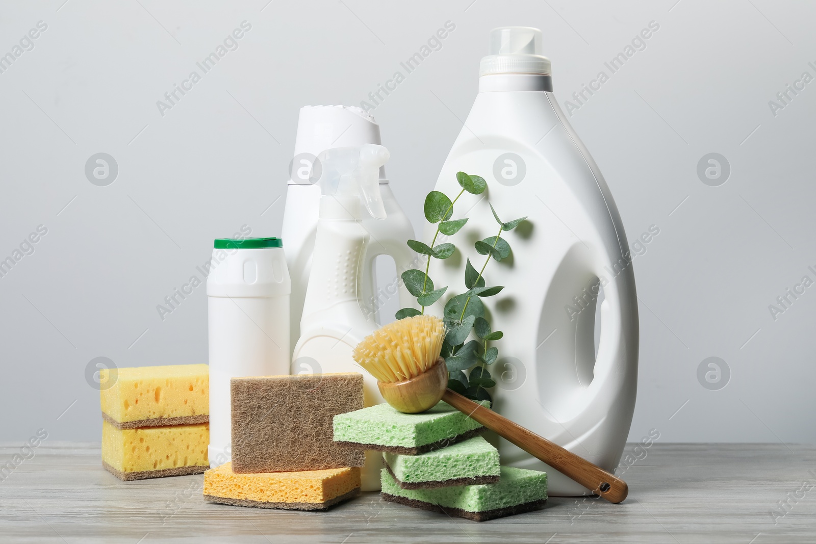 Photo of Eco-friendly cleaning products, supplies and eucalyptus branches on wooden table