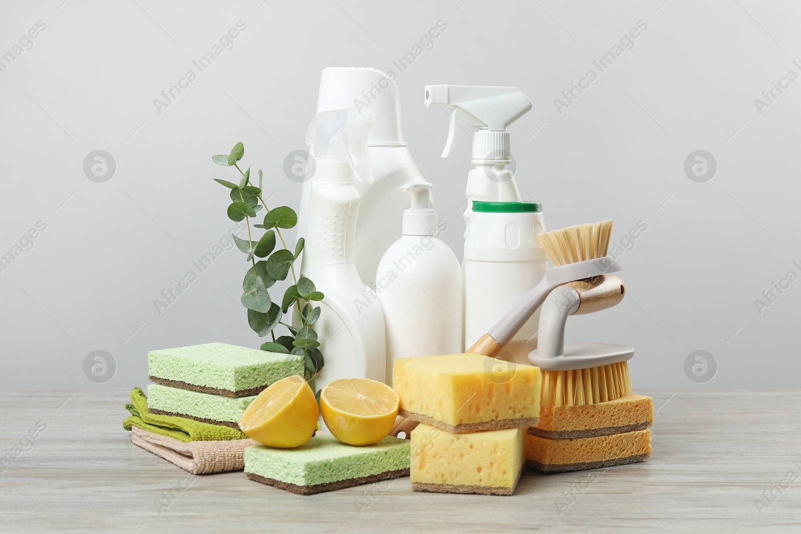 Photo of Eco-friendly cleaning products, supplies and eucalyptus branches on wooden table