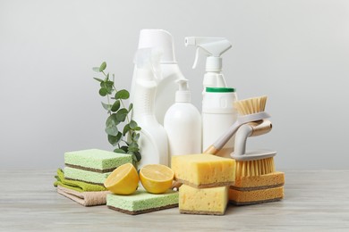 Photo of Eco-friendly cleaning products, supplies and eucalyptus branches on wooden table