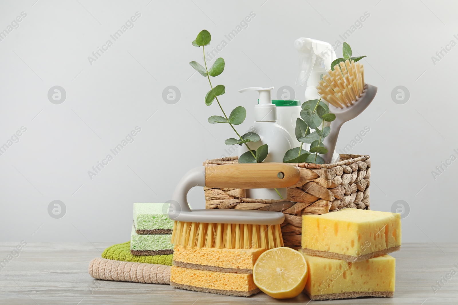 Photo of Eco-friendly cleaning products, supplies and eucalyptus branches on wooden table, space for text