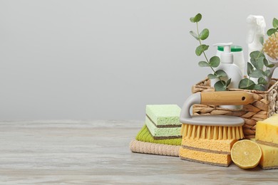 Photo of Eco-friendly cleaning products, supplies and eucalyptus branches on wooden table, space for text