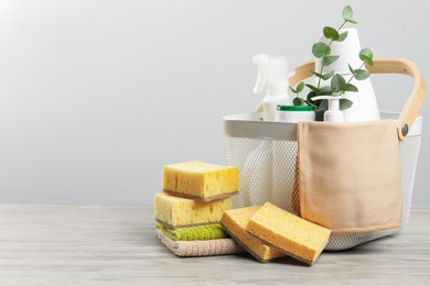 Photo of Eco-friendly cleaning products, supplies and eucalyptus branches on wooden table, space for text