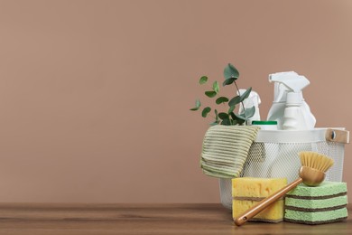 Photo of Eco-friendly cleaning products, supplies and eucalyptus branches on wooden table, space for text