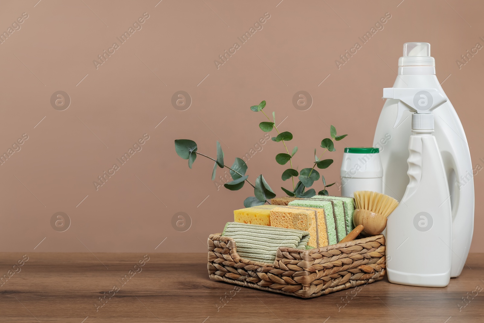 Photo of Eco-friendly cleaning products, supplies and eucalyptus branches on wooden table, space for text