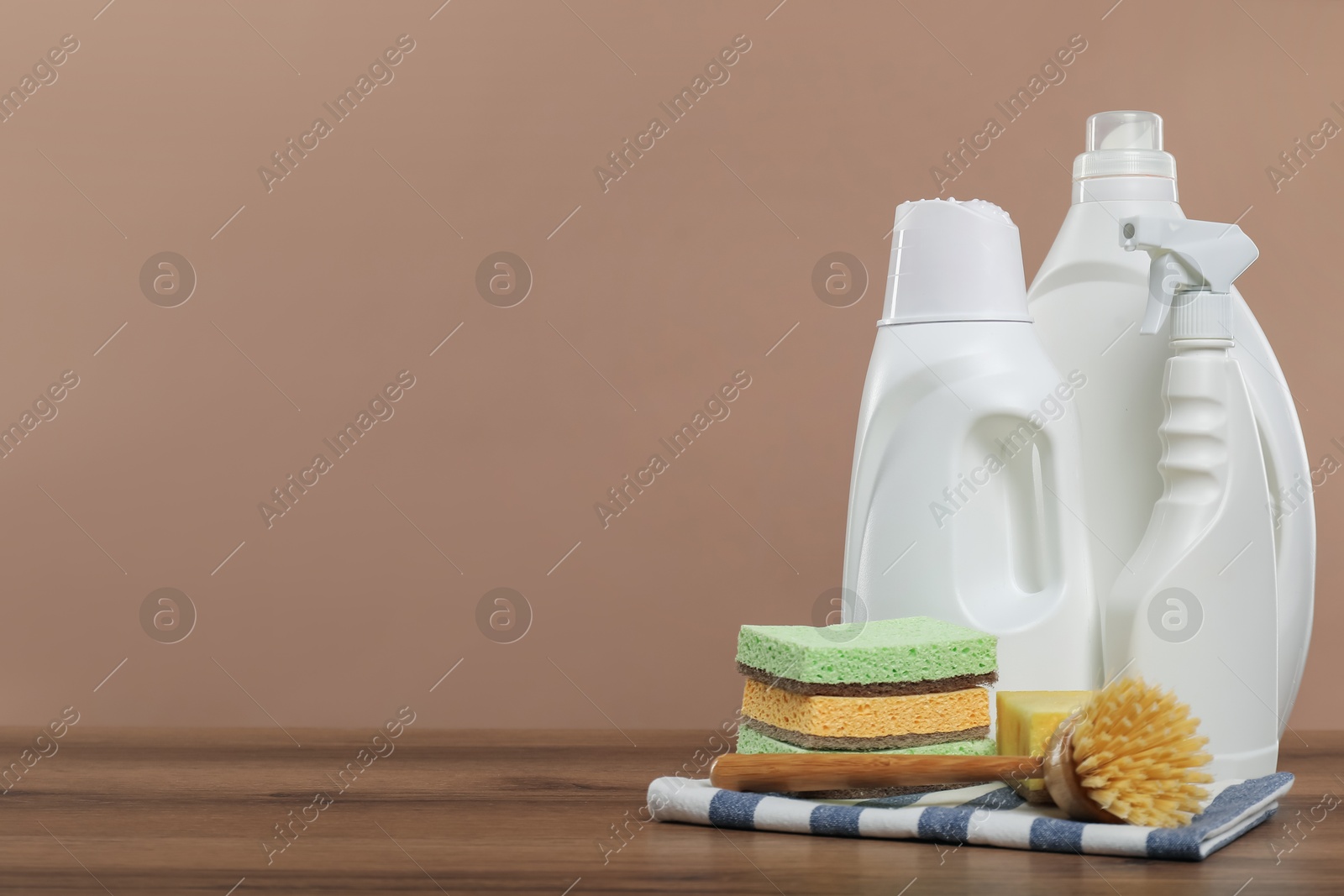 Photo of Eco-friendly cleaning products and supplies on wooden table against beige background, space for text