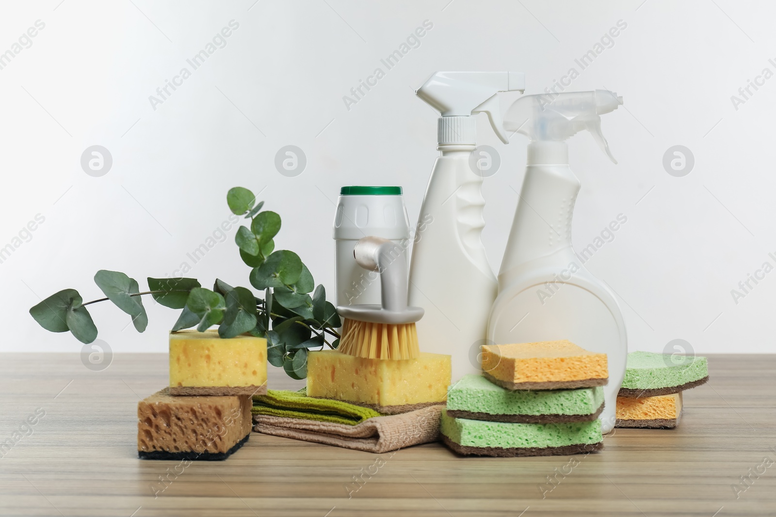 Photo of Eco-friendly cleaning products, supplies and eucalyptus branches on wooden table