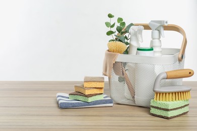 Photo of Eco-friendly cleaning products, supplies and eucalyptus branches on wooden table, space for text