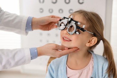 Photo of Ophthalmologist examining patient's vision with trial frame in clinic, closeup