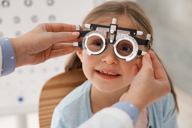 Photo of Ophthalmologist examining patient's vision with trial frame in clinic, closeup