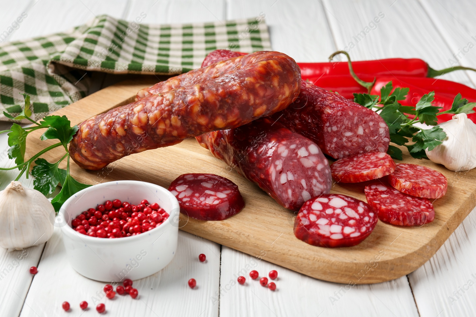 Photo of Different smoked sausages and spices on white wooden table, closeup