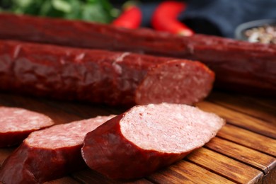 Photo of Delicious thin smoked sausage on table, closeup