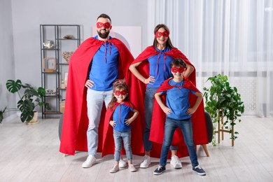 Parents and their children wearing superhero costumes at home