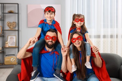 Photo of Parents and their children wearing superhero costumes at home