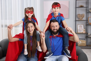 Photo of Parents and their children wearing superhero costumes at home