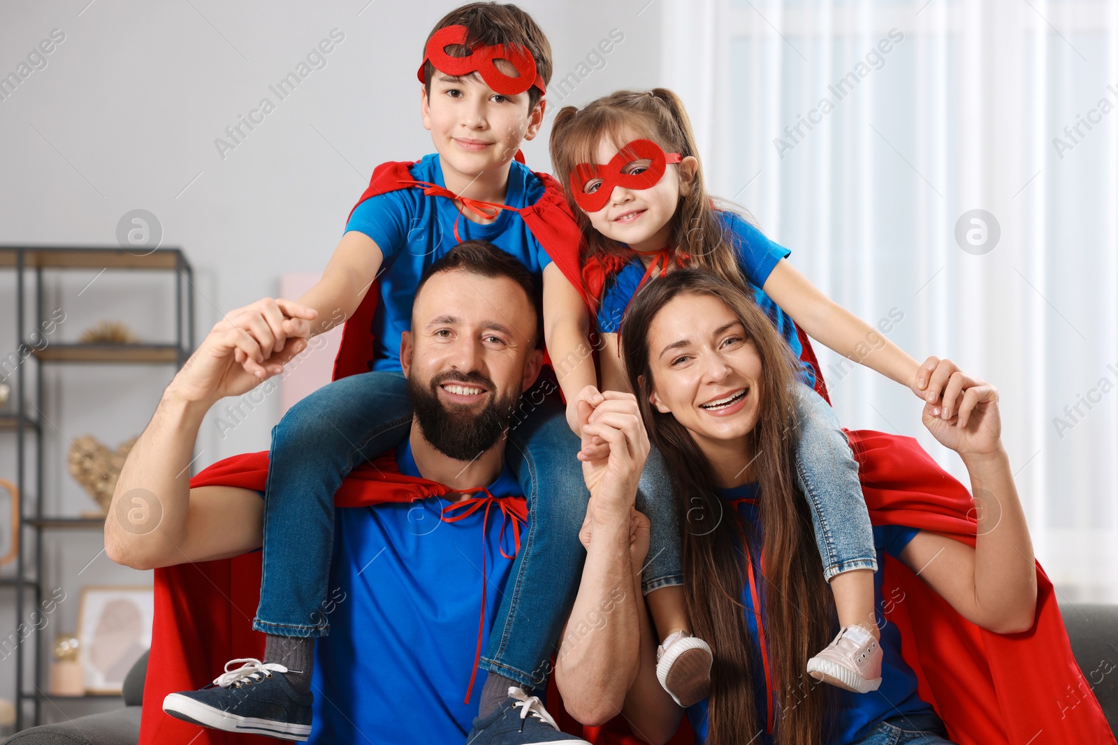 Photo of Parents and their children wearing superhero costumes at home