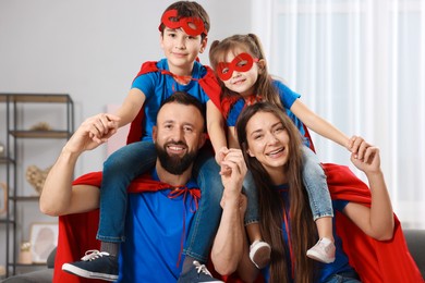 Photo of Parents and their children wearing superhero costumes at home