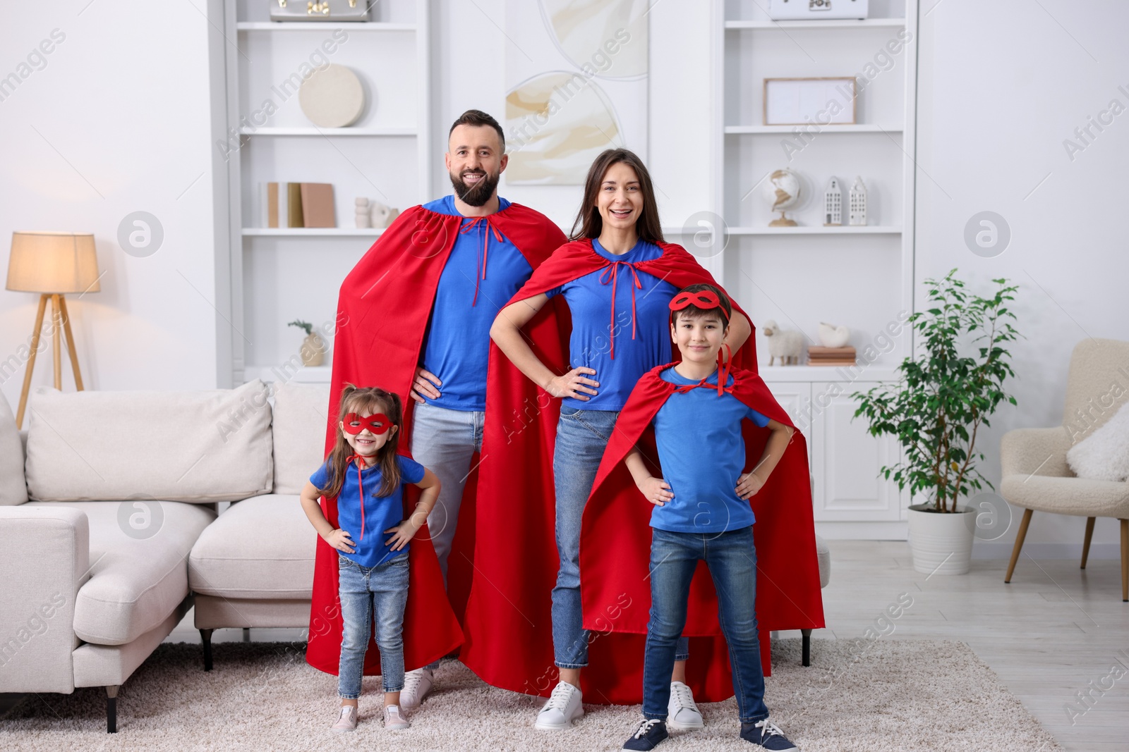 Photo of Parents and their children wearing superhero costumes at home