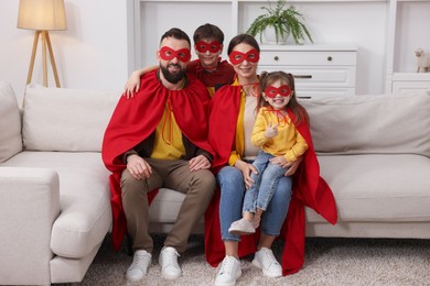 Photo of Parents and their children wearing superhero costumes at home