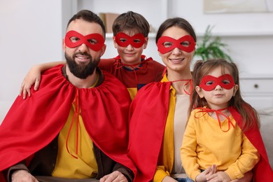 Photo of Parents and their children wearing superhero costumes at home