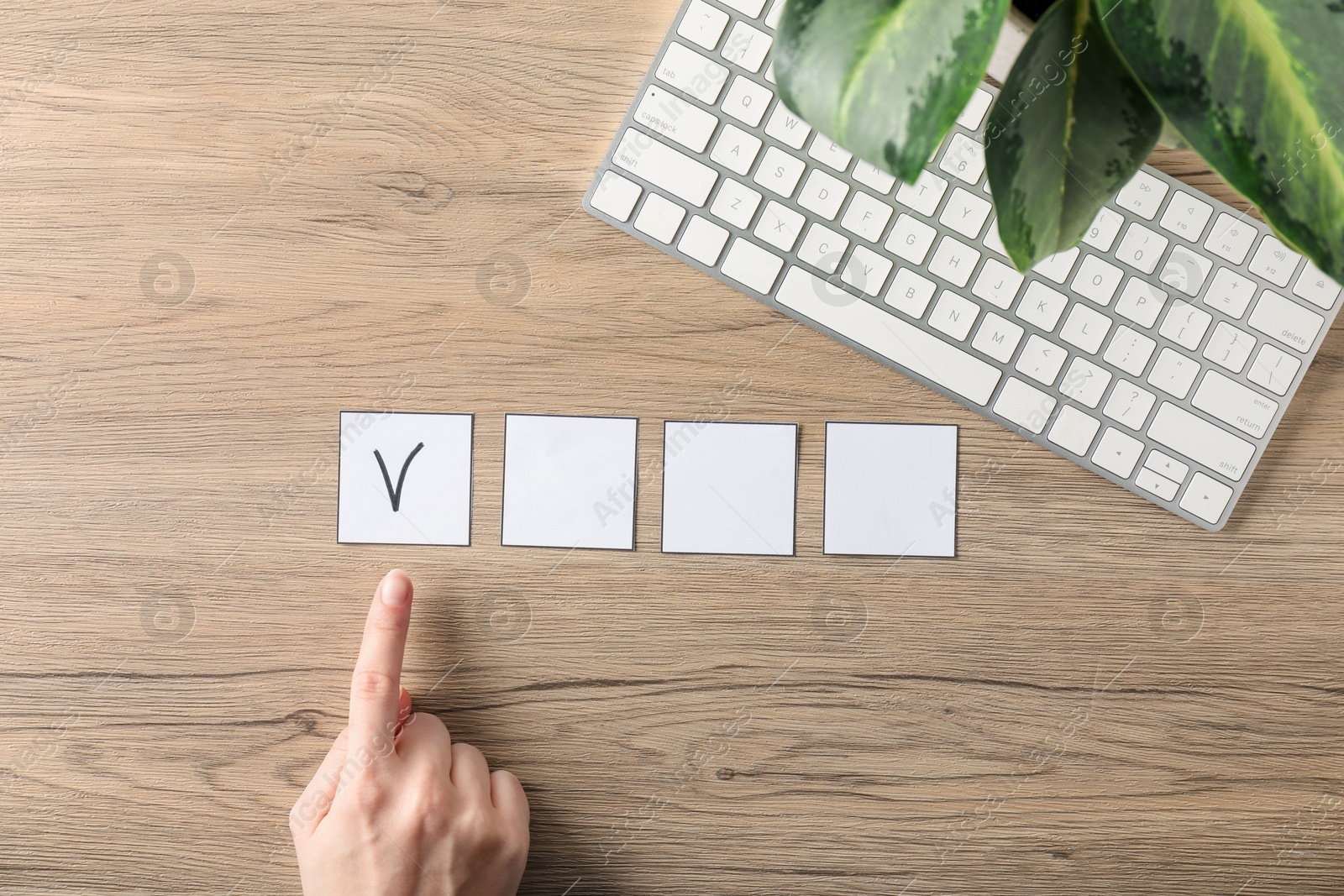 Photo of Woman pointing at checkbox with tick mark at wooden table, top view