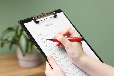 Photo of Woman filling Checklist with marker indoors, closeup