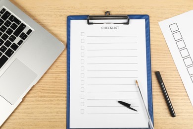 Photo of Checklist with checkboxes, pen, marker and laptop on wooden table, flat lay