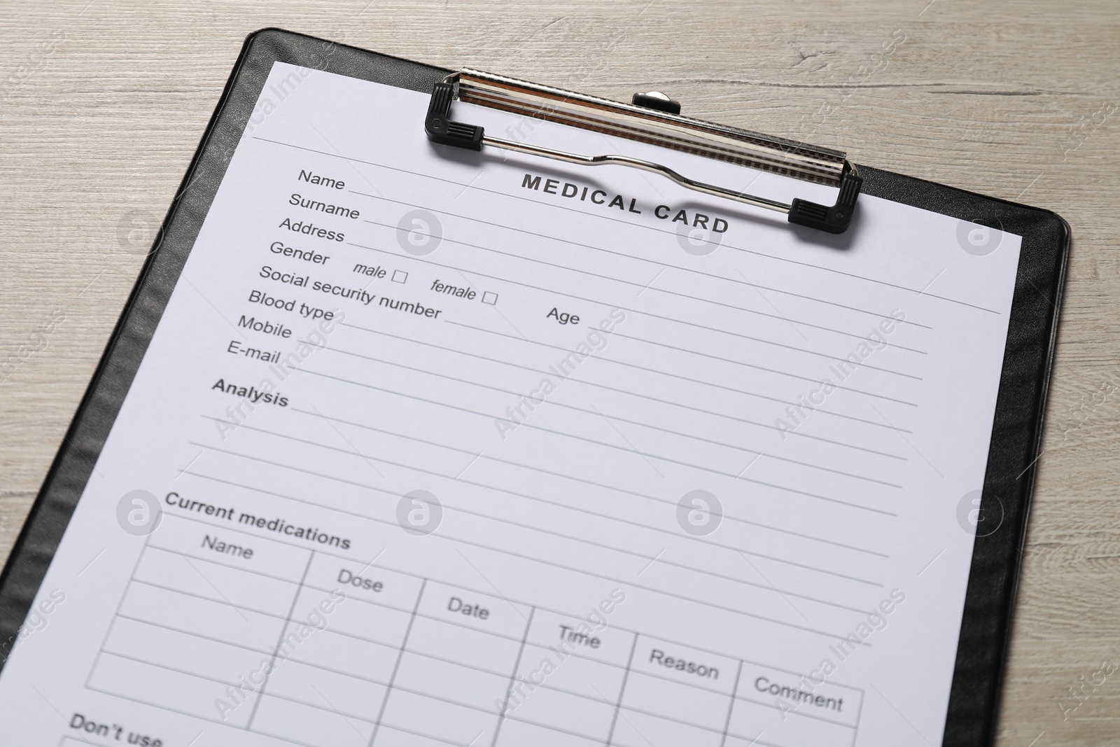 Photo of Medical card form on light wooden background, closeup