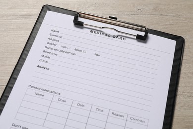 Medical card form on light wooden background, closeup