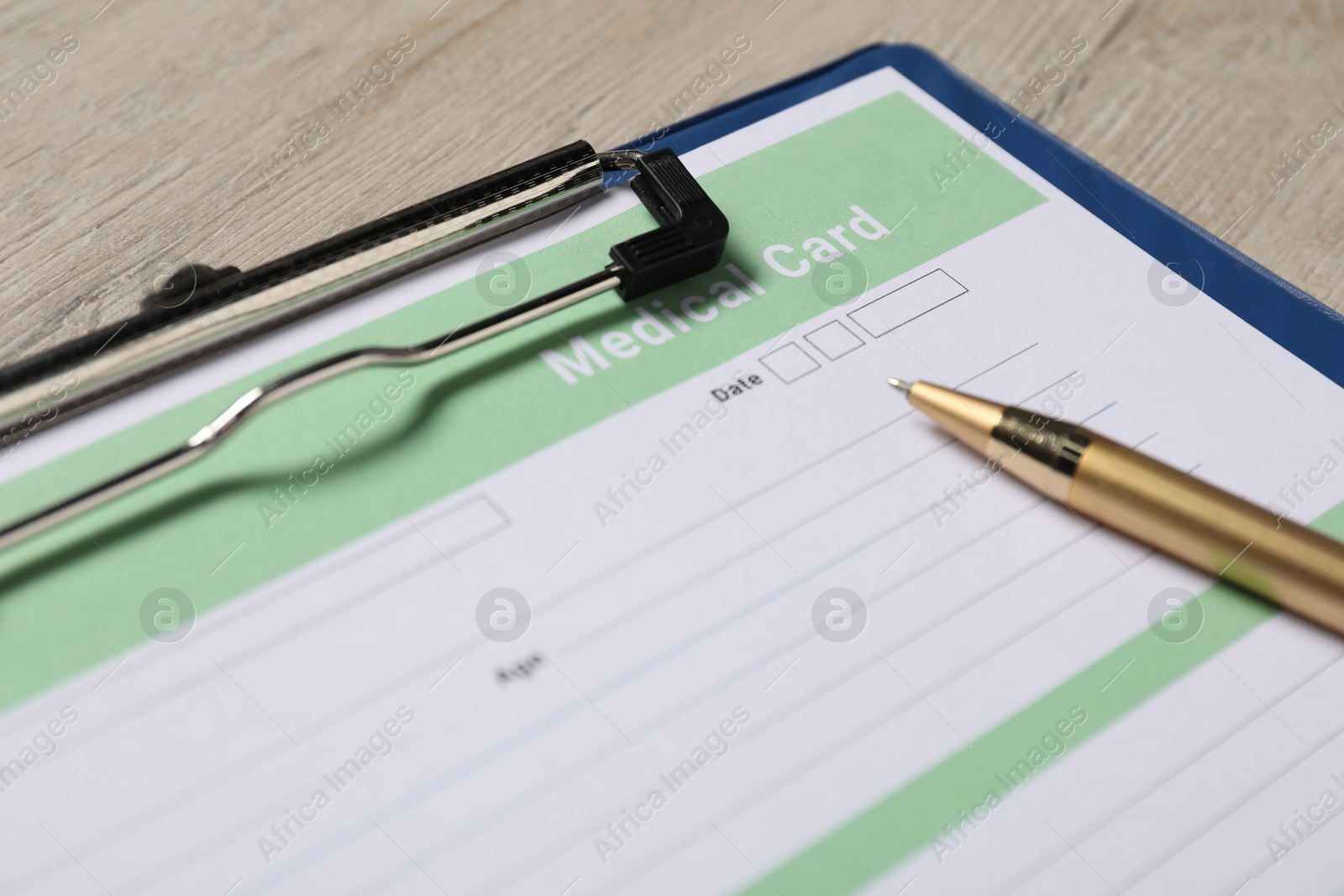 Photo of Medical card form and pen on light wooden background, closeup